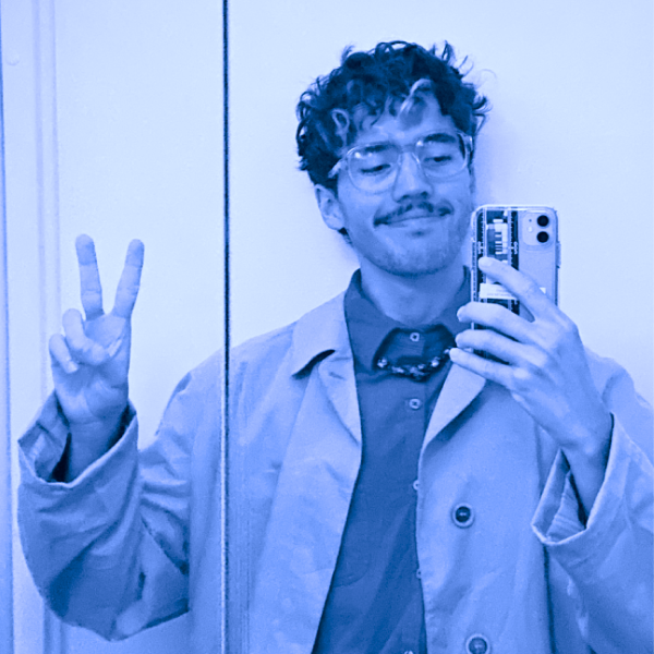 A mirror selfie of John, the author of this blog. He is smiling and holding a up his right hand on a peace sign.